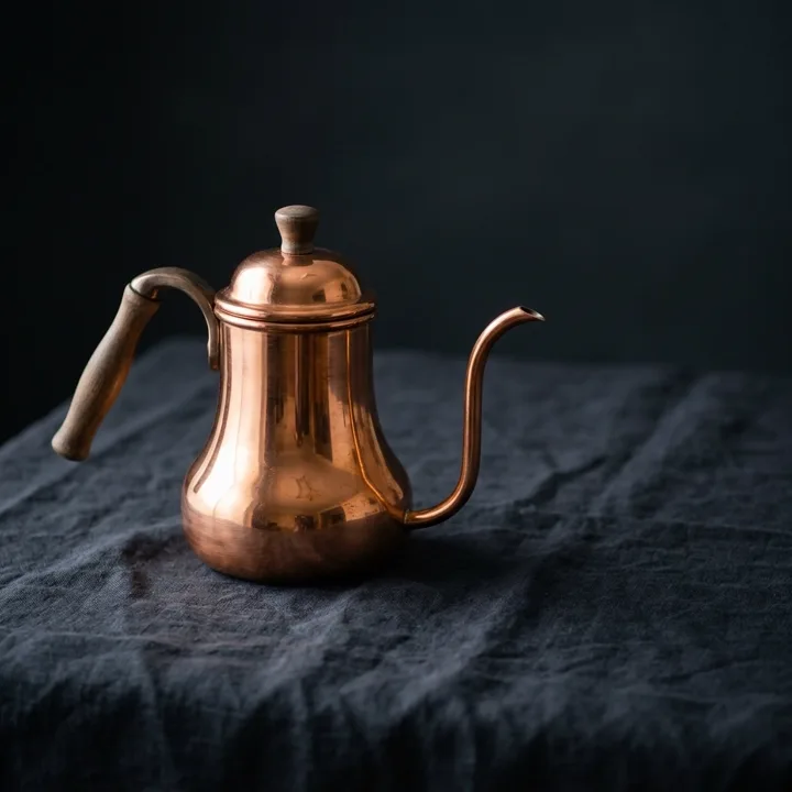 Polished copper coffee pot on dark linen — generated with Nano Banana 2.1