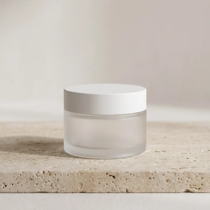 Frosted glass skincare jar on travertine — generated with Nano Banana Pro